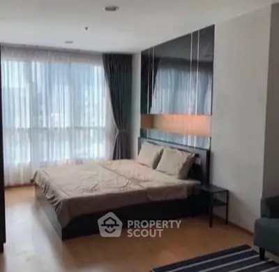 Modern bedroom with large window and stylish decor in a high-rise apartment.