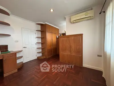 Spacious room with wooden flooring and built-in shelves, perfect for a home office or study.