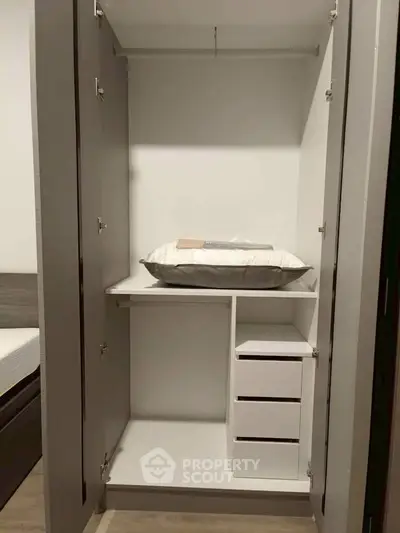 Spacious modern wardrobe with shelves and drawers in a stylish bedroom setting.