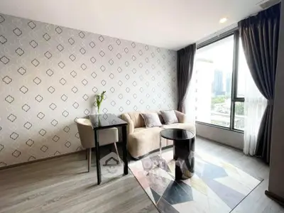 Modern living room with stylish decor and large window offering city views