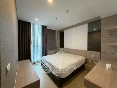 Modern bedroom with large window and stylish wooden furnishings