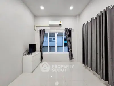 Spacious modern living room with sleek tile flooring and large window for natural light.