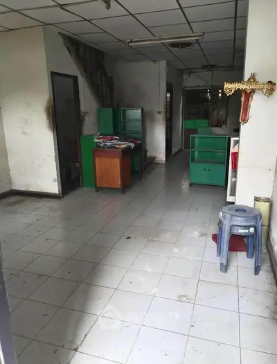 Spacious interior with tiled flooring and green cabinets, ideal for creative workspace.