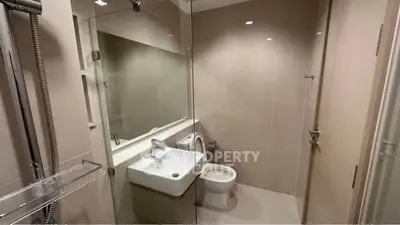 Modern bathroom with glass shower and sleek fixtures in a contemporary apartment.