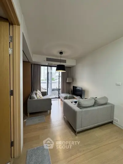 Modern living room with balcony view and stylish gray sofas