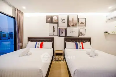 Modern bedroom with two double beds, stylish wall art, and ambient lighting for a cozy atmosphere.