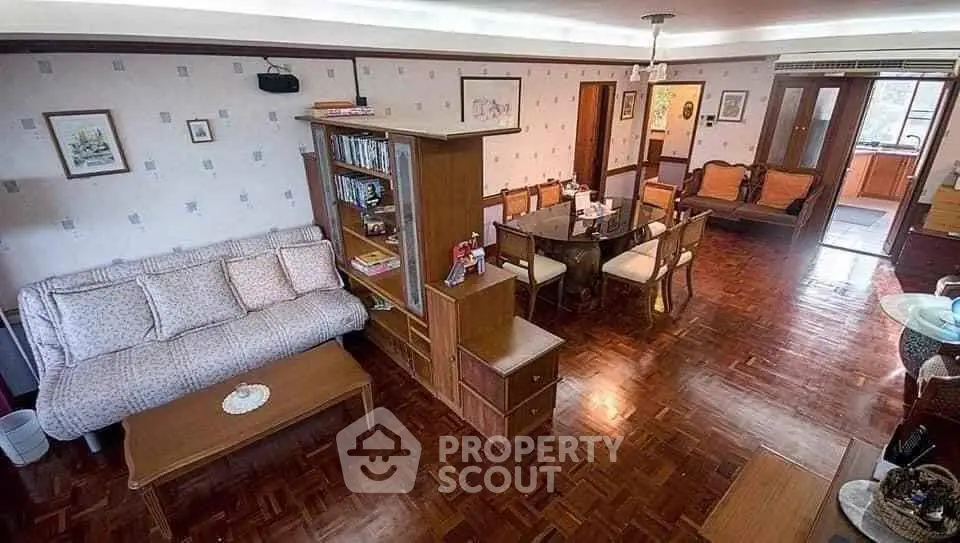 Spacious living room with wooden flooring and elegant dining area in a cozy apartment.