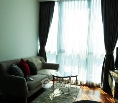 Bright living room with large window, cozy sofa, and stylish decor in modern apartment.