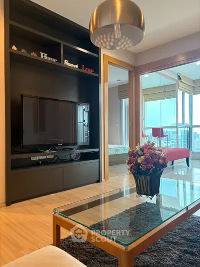 Modern living room with sleek TV setup and city view balcony.