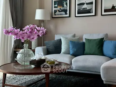Stylish living room with modern decor, plush sofa, and elegant coffee table with flowers.