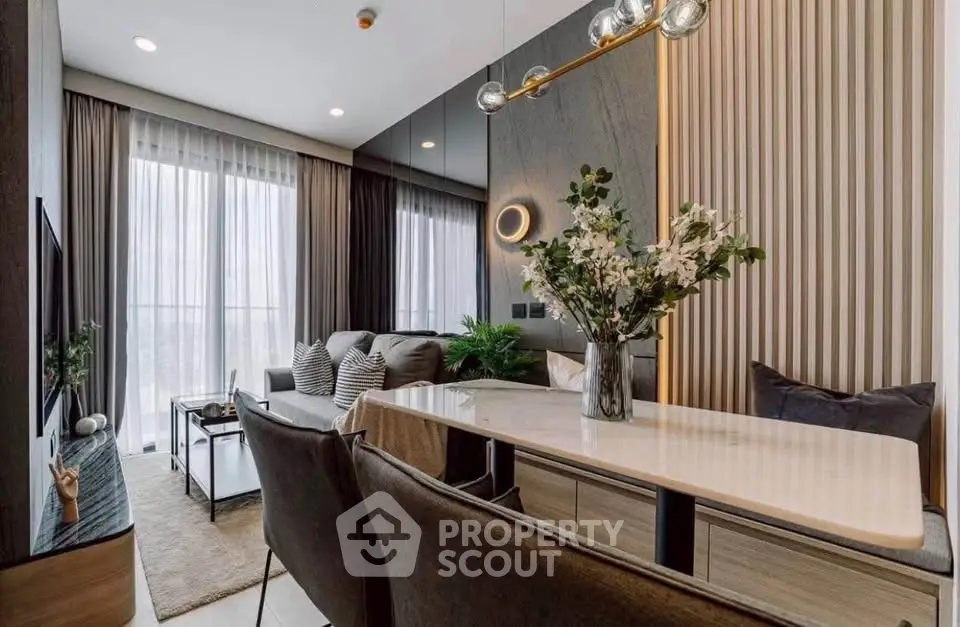 Modern living room with elegant decor and large windows offering natural light.