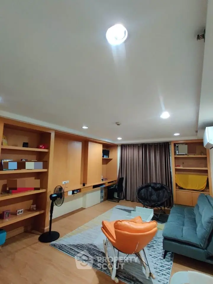 Spacious living room with modern furniture and built-in shelves, perfect for relaxation and entertainment.