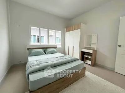 Spacious bedroom with modern furniture and natural light