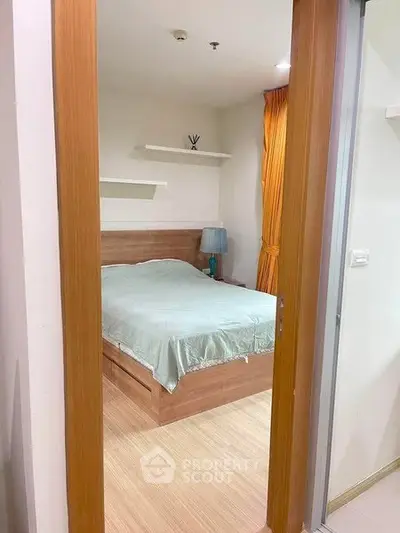 Cozy bedroom with wooden flooring and modern decor in a stylish apartment.