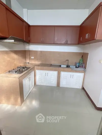 Modern kitchen with gas stove and ample storage in a cozy apartment.