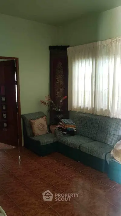 Cozy living room with green sofa and decorative curtains