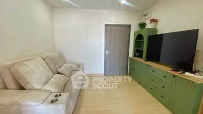 Cozy living room with plush sofa and modern entertainment unit in a stylish apartment.