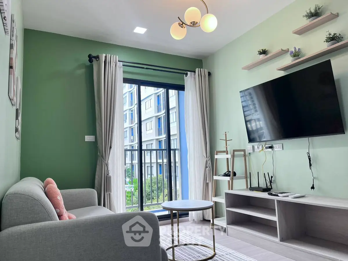 Modern living room with green accent wall, wall-mounted TV, and balcony view in stylish apartment.