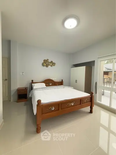 Spacious bedroom with elegant wooden bed and ample natural light
