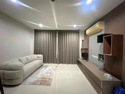 Modern living room with sleek furniture and air conditioning, featuring a cozy sofa and elegant curtains.