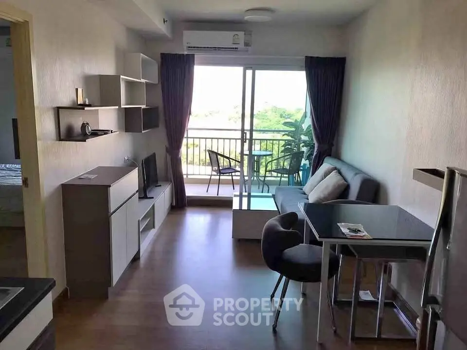 Modern living room with balcony view, stylish furniture, and natural light in a cozy apartment.