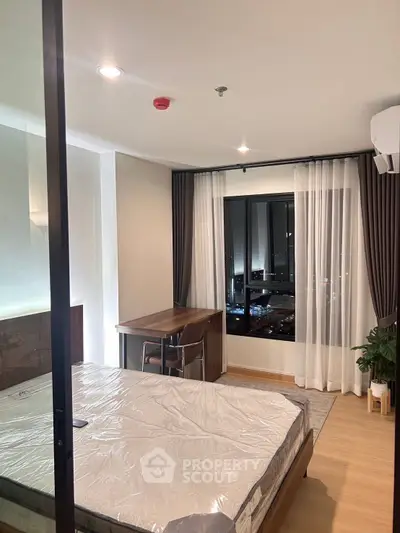 Modern bedroom with large window and wooden furniture, offering a cozy and inviting atmosphere.