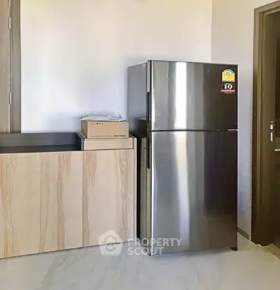 Modern kitchen with sleek stainless steel fridge and minimalist cabinetry.
