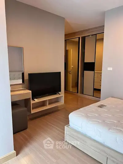 Modern bedroom with sleek design, featuring a comfortable bed, TV, and stylish wardrobe.