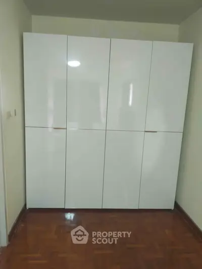 Spacious white wardrobe with sleek design in a modern bedroom setting.