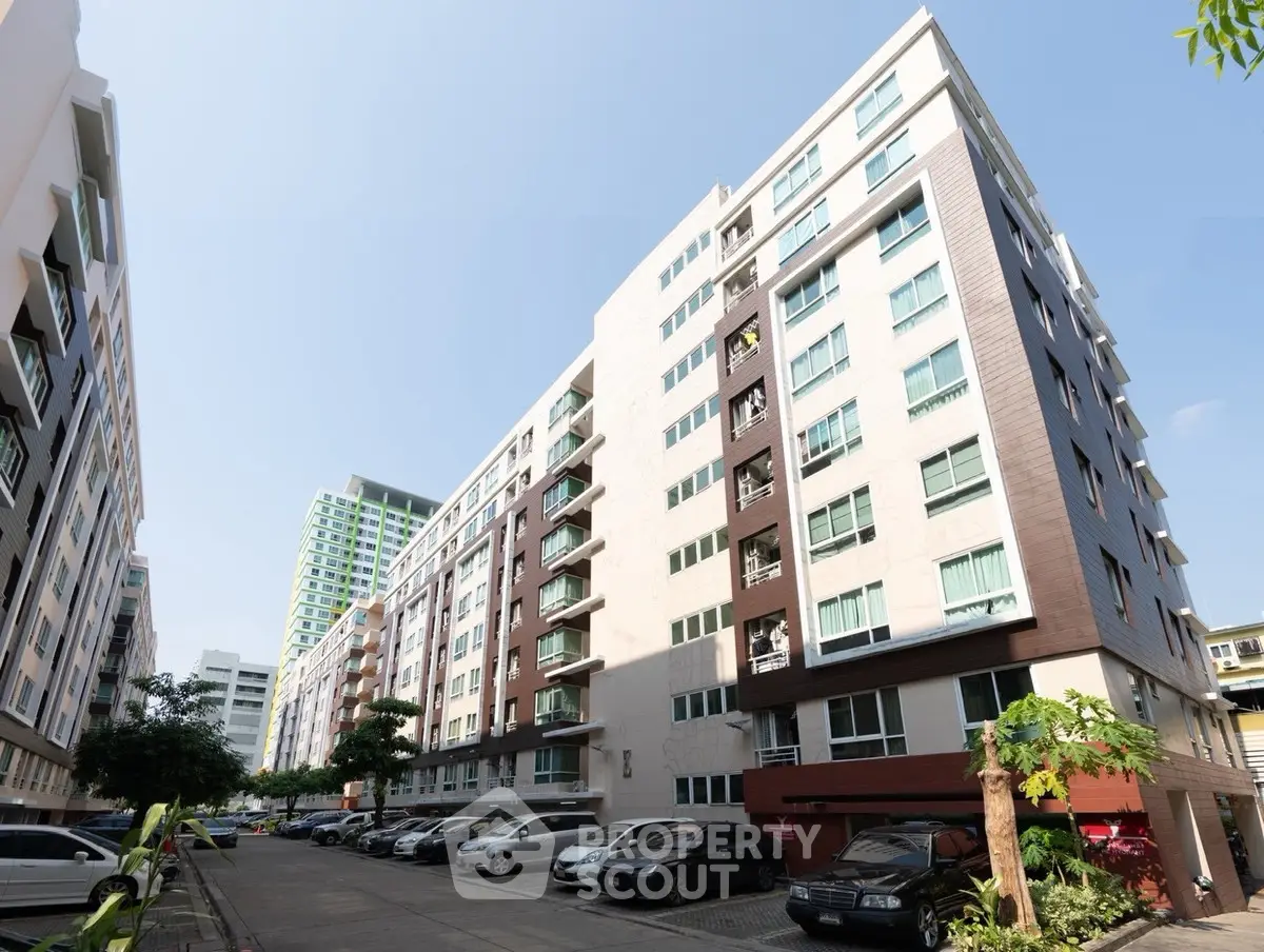 Modern urban apartment building with parking and clear blue sky
