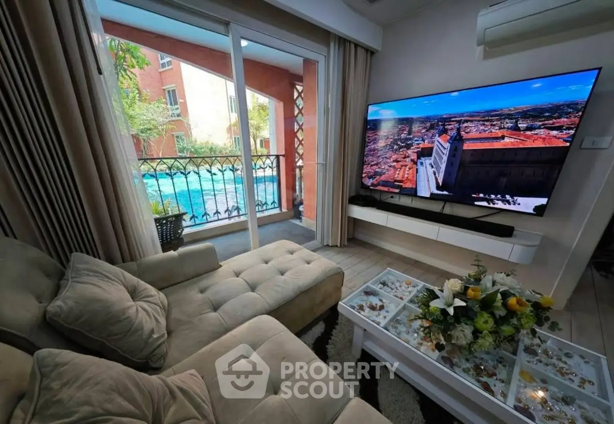Luxurious living room with pool view and large TV, perfect for relaxation.