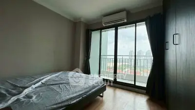 Spacious bedroom with balcony and city view in modern apartment