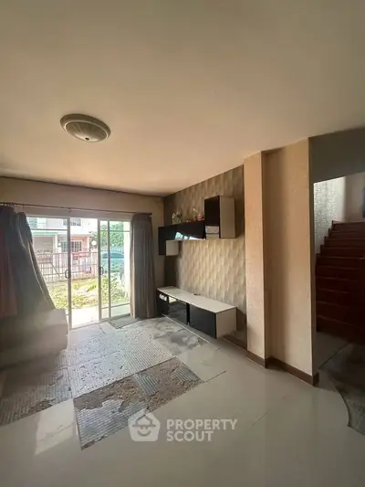 Spacious living room with modern decor and large sliding glass doors leading to a garden view.