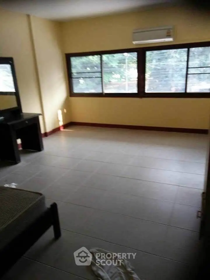 Spacious unfurnished room with large windows and air conditioning, ideal for customization.