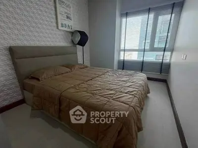 Cozy bedroom with modern decor and large window for natural light.