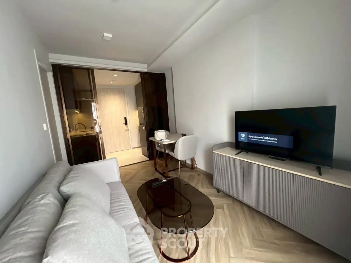 Modern living room with sleek furniture and open kitchen layout, perfect for urban living.