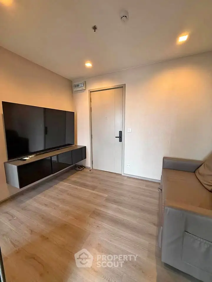 Modern living room with sleek TV setup and comfortable seating in a stylish apartment.