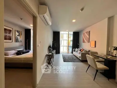 Spacious modern apartment with open living room and cozy bedroom, featuring stylish decor and natural light.