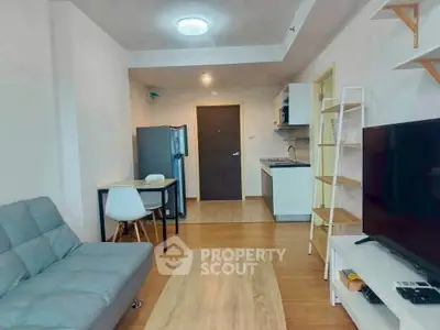 Modern living room with open kitchen, featuring sleek furniture and contemporary design.