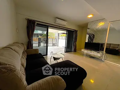 Spacious living room with modern decor and large sliding glass doors to balcony.