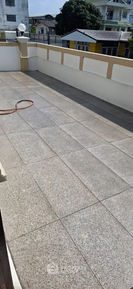 Spacious rooftop terrace with tiled flooring and city views, perfect for outdoor relaxation and entertainment.