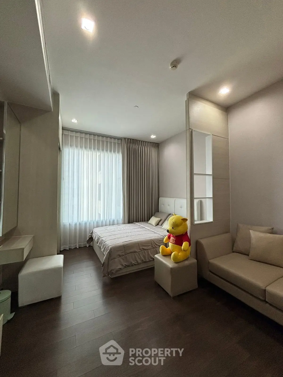 Spacious bedroom with elegant decor and plush furnishings, featuring a cozy bed and stylish seating area.