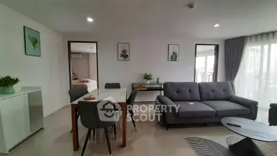 Modern living room with stylish decor and open layout, featuring a cozy sofa and elegant dining area.