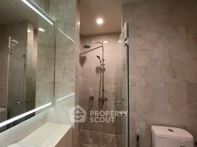 Luxurious modern bathroom with elegant marble tiles and sleek shower design.