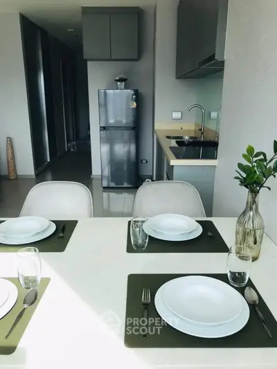 Modern kitchen with dining table set, sleek appliances, and minimalist decor