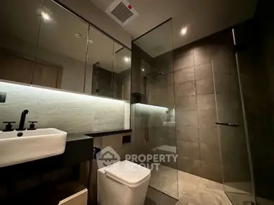 Modern bathroom with sleek design, glass shower, and elegant fixtures.