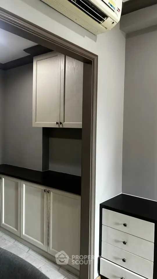 Modern storage area with sleek cabinetry and air conditioning unit in a stylish home interior.