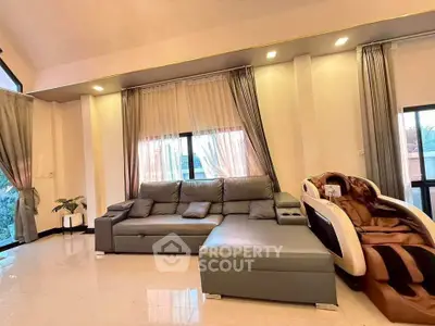 Luxurious living room with modern sofa and massage chair, featuring elegant curtains and ample natural light.