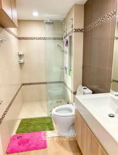 Modern bathroom with glass shower, sleek sink, and stylish tiles