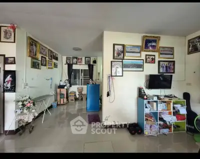 Spacious living room with modern decor and wall art, featuring a TV and storage unit.